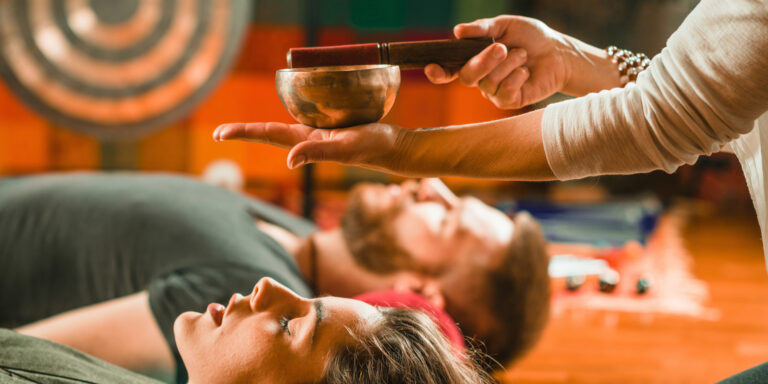 Sound Practitioner Using A Singing Bowl To Treat Others Cropped