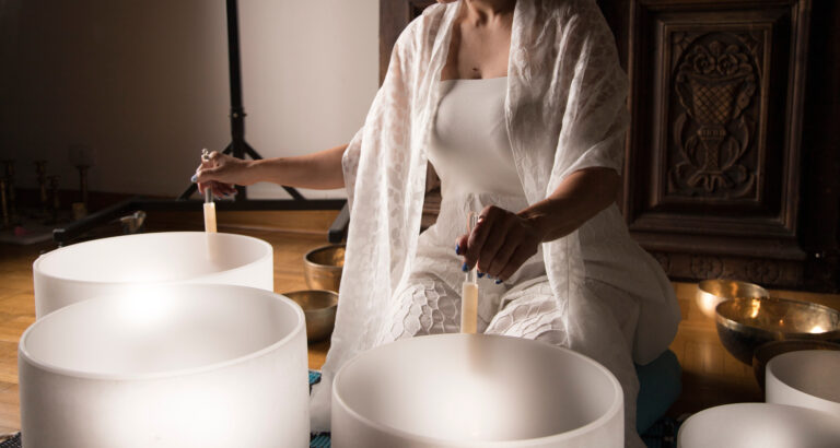 Woman Playing crystal singing bowls